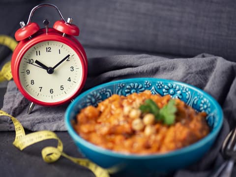 Wecker neben Schale mit Essen