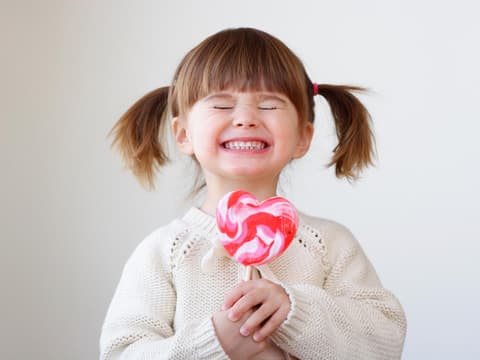 Kleines Mädchen lacht mit Riesenlolli