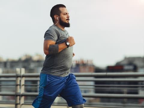 Mann joggt auf Promenade
