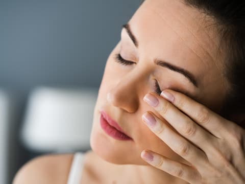 Müde Frau reibt sich die Augen