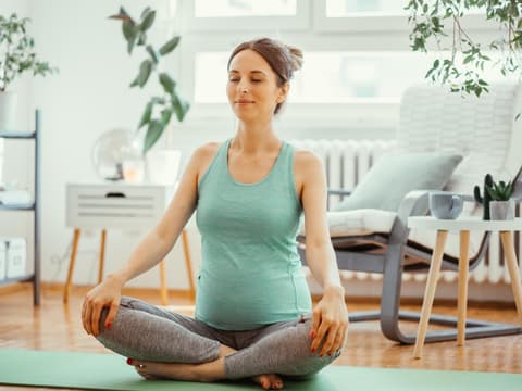 schwangere Frau auf Yogamatte