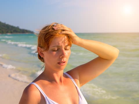 Frau steht in der Sonne