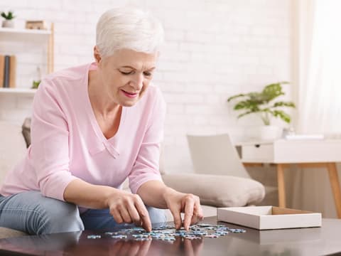 Frau mit Alzheimer löst Puzzle