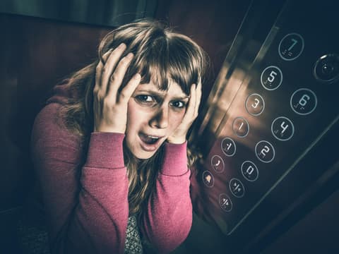 Frau mit Klaustrophobie im Fahrstuhl