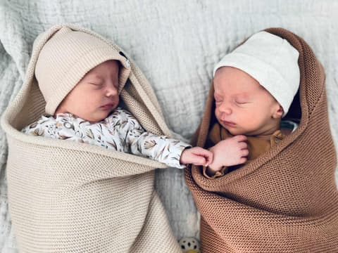 Zwei Säuglinge schlafen in gestrickten Säckchen