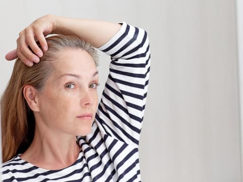 Frau mit grauem Haaransatz