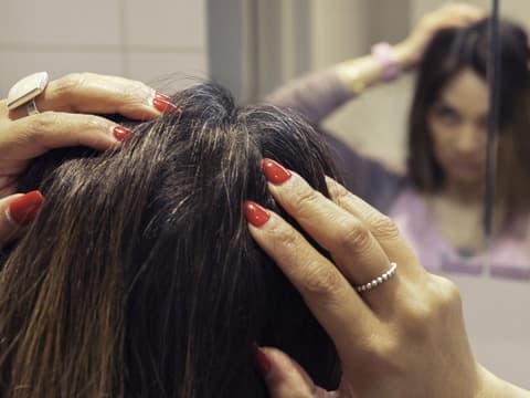 Frau entdeckt graue Haare