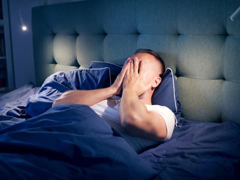 Mann liegt im Bett