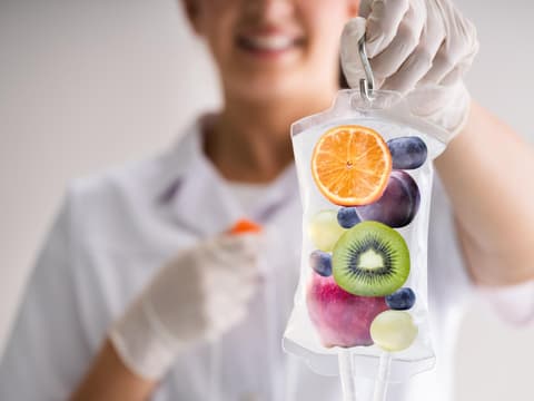 Frau hält Vitamin C Infusion