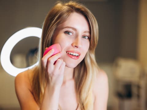 Frau nutzt Primer vor dem Make up