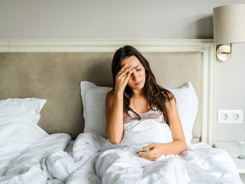 Kranke Frau liegt im Bett