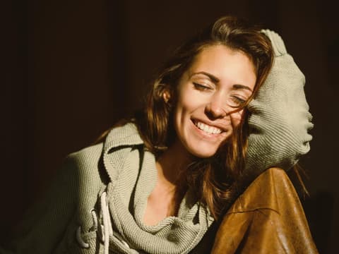 Frau lacht mit geschlossenen Augen