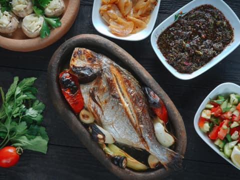 Gegrillter Fisch mit Salat und mediterranen Beilagen