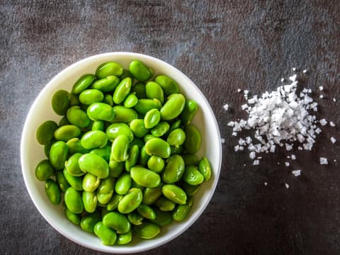 Edamame in einer Schale mit Salz auf einer Schieferplatte