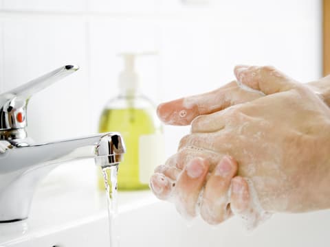 Person wäscht sich mit Flüssigseife die Hände