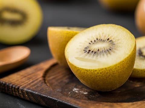 Gelbe Kiwi liegt auf einem Holzbrett
