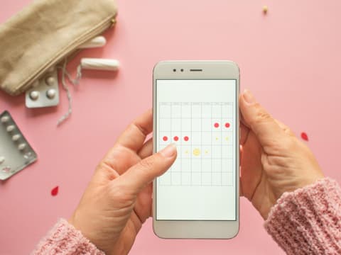 Frau trackt Periode in App