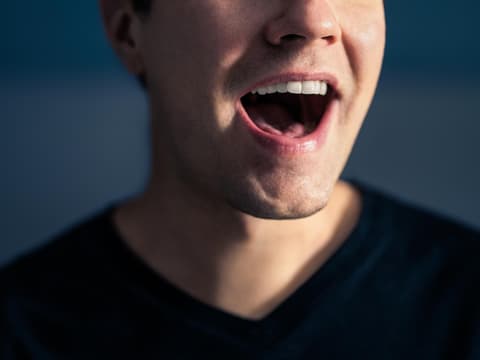 Mann spricht mit offenem Mund
