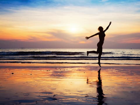 Frau tanzt am Meer