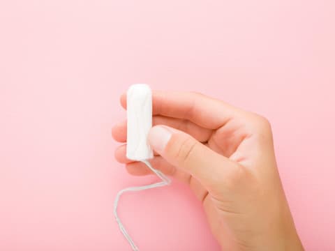 Frau hält Tampon in der Hand