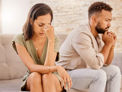 Paar sitzt nach Streit gemeinsam auf dem Sofa