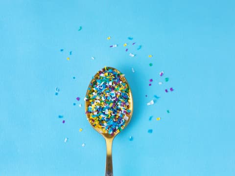 Mikroplastik auf Teelöffel vor blauem Hintergrund