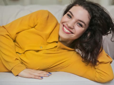 Lächelnde Frau liegt auf dem Sofa