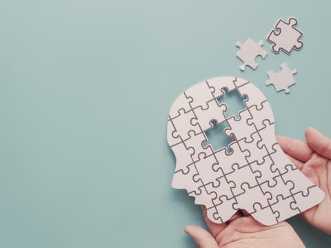 Puzzle eines menschlichen Kopfes im Profil mit einigen Teilen, die fehlen