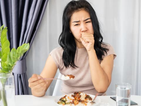 Frau verschluckt sich beim Essen