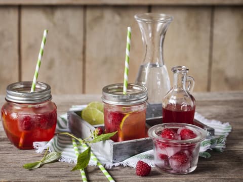 Gläser mit Himbeerlimonade, Minze und Limette.