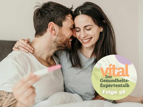 Glückliches Paar hält positiven Schwangerschaftstest in der Hand