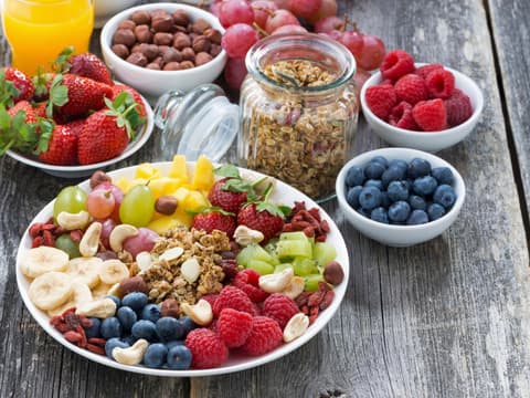 Schälchen mit gesunden Lebensmitteln wie Beeren und Nüssen