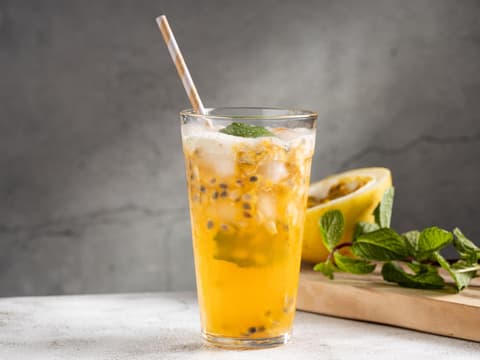 Ein Glas mit Maracujalimonade mit Minze.