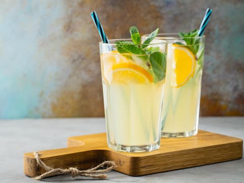 Zwei Gläser Orangenlimonade mit Minze.