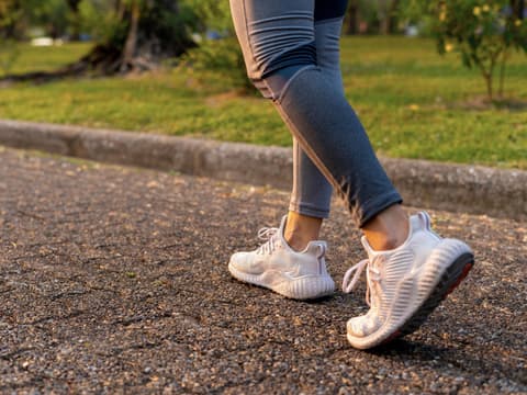 Frauenbeine in Turnschuhen fotografiert beim Rückwärtslaufen