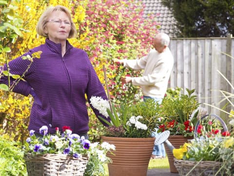 Frau hat Rückenschmerzen nach Gartenarbeit