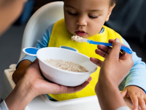 Ein Baby wird mit Babybrei gefüttert.
