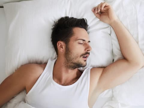 Mann schläft auf dem Bett