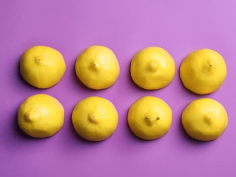 aufgeschnittene Zitronenhälften auf lila Untergrund