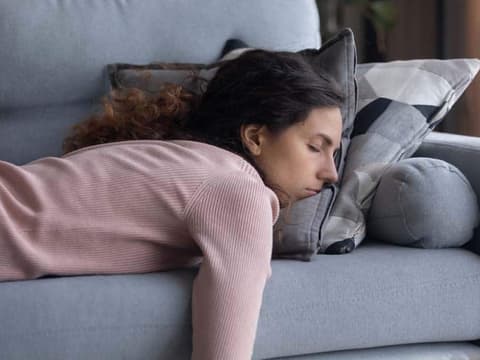 Frau schläft auf dem Sofa