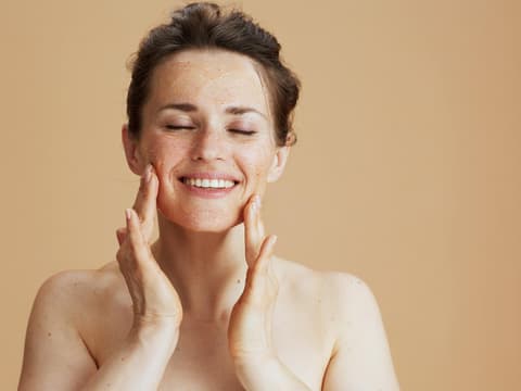 Frau nutzt Peeling im Gesicht