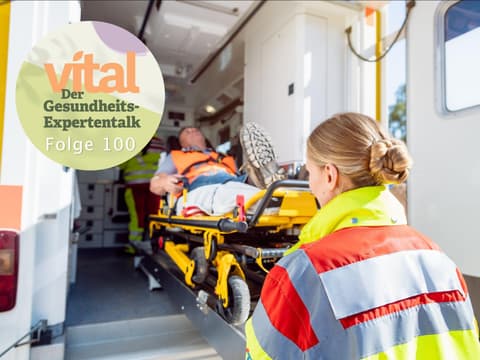 Sanitäter schieben Mann auf Liege in Krankenwagen