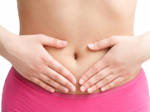 Frau hält sich die Hände vor den Bauch
