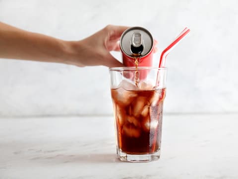 Cola wird in ein Glas eingegossen