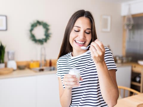 Frau isst Naturjoghurt