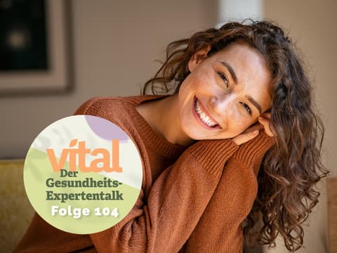 Lächelnde Frau mit dem Button des Vital-Podcasts
