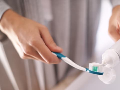 Frau trägt Zahnpasta auf ihre Zahnpasta auf