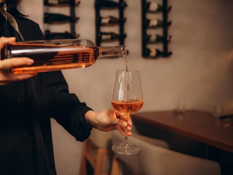 Frau schenkt sich Wein ein