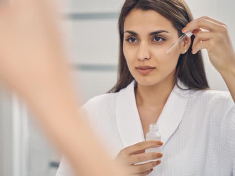 Frau trägt ein Serum auf