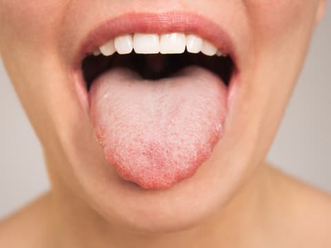 Psychische Faktoren können sich in körperlichen Symptomen wie einem Kribbeln der Zunge äußern.